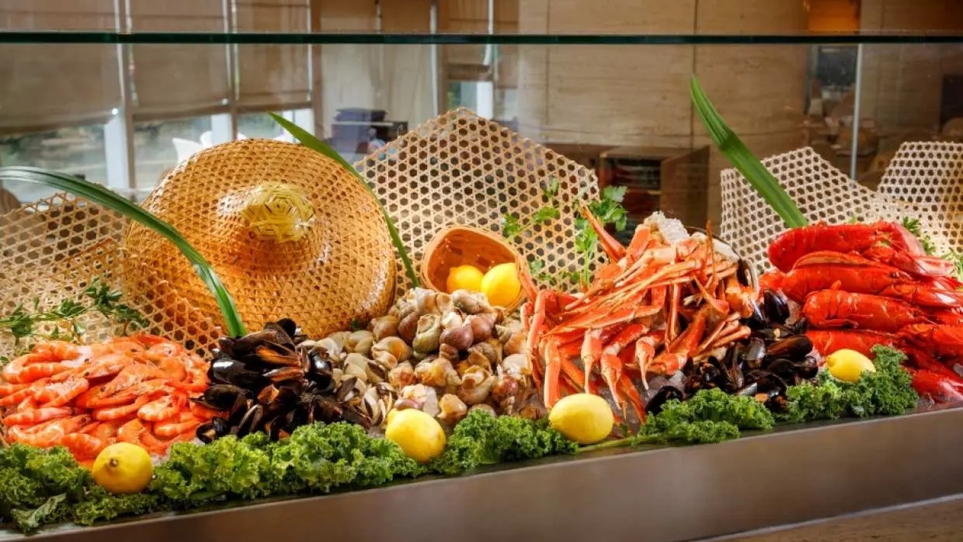 都會海逸酒店 Promenade「歲暮蟹香」自助餐官方宣傳圖 — 冰鎮海鮮檯上擺滿鮮紅蟹殼、龍蝦、貝類,伴檸檬、綠葉、紅色花卉與藤編飾物,滿滿螃蟹宴席擺盤(KKday 官方圖片)
